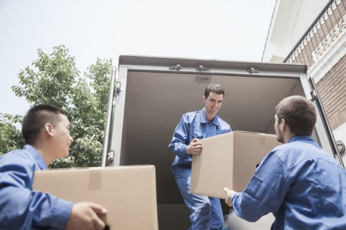 Local piano moving team navigating stairs in Belsizepark