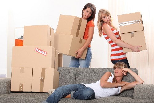 Professional movers carrying furniture during a Belsizepark relocation